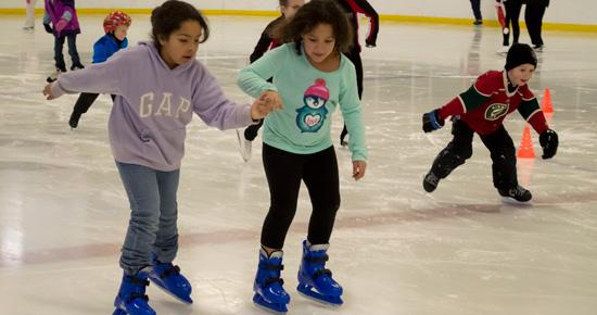 Two young girls skating at Aldrich Arena Two young girls skating at Aldrich Arena